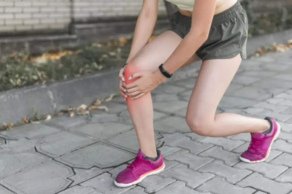 Patient gripping their knee in pain after an injury