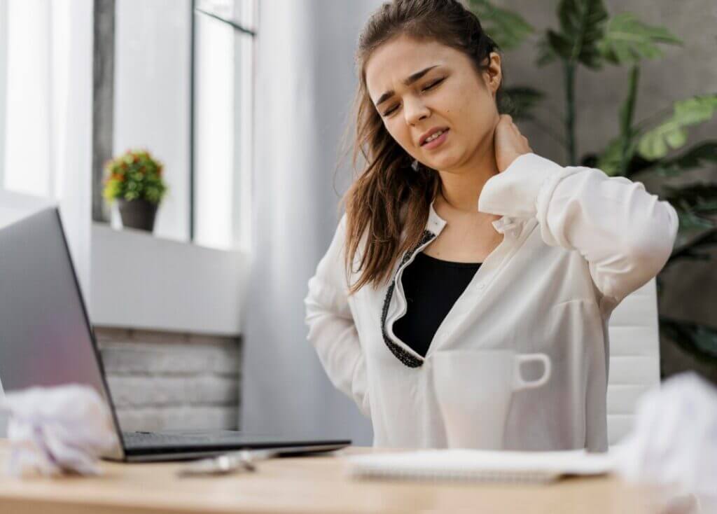 Patient sitting at a desk, experiencing neck pain